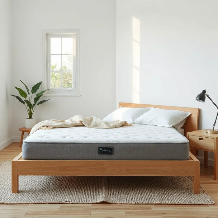 Neatly made bed with a breathable eco-friendly mattress and natural linens in soft daylight
