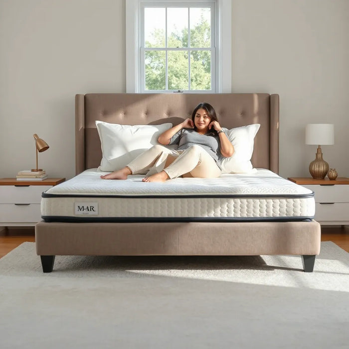 Plus-size sleeper sitting on a neatly made bed with a supportive medium-firm mattress