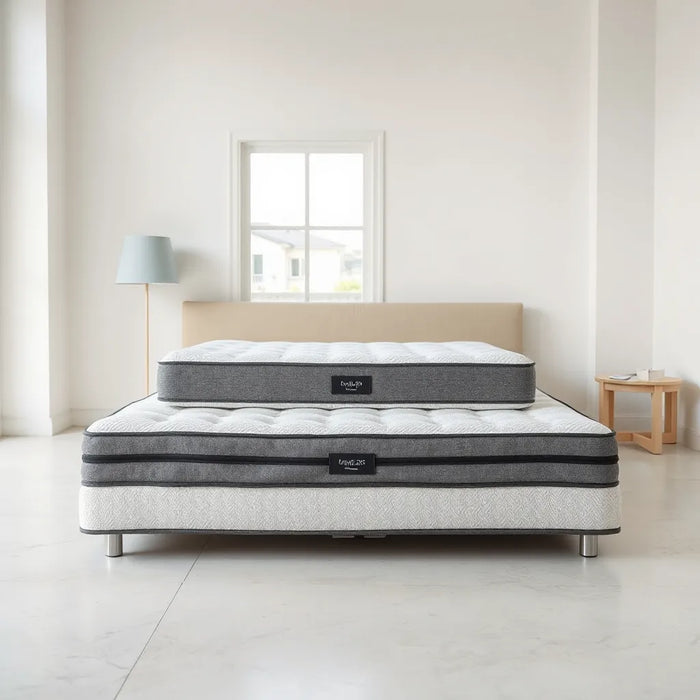 Three modern mattresses arranged side by side with visible fabric textures in a minimalist showroom