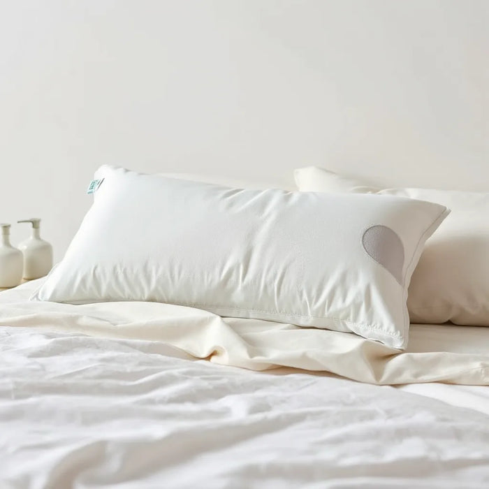 Zoned shoulder support pillow with contoured zones on a neatly made bed