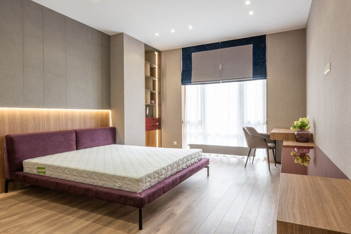 Contemporary interior design of modern bedroom with comfortable bed without sheets and vanity table near window