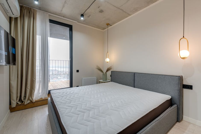 Minimalist bedroom featuring modern furnishings and stylish lighting, ideal for contemporary living.