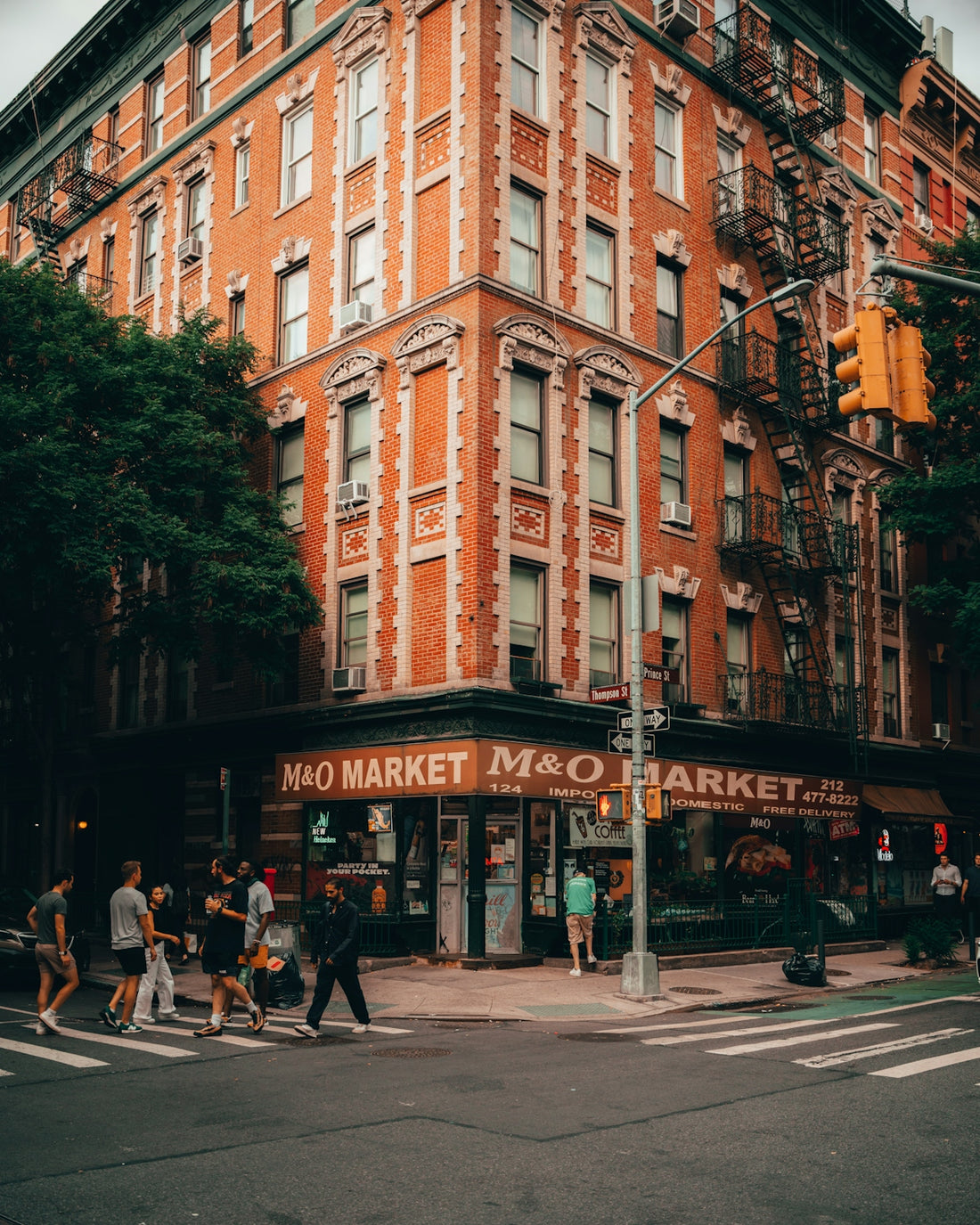 a group of people walking on the sidewalk next to a building