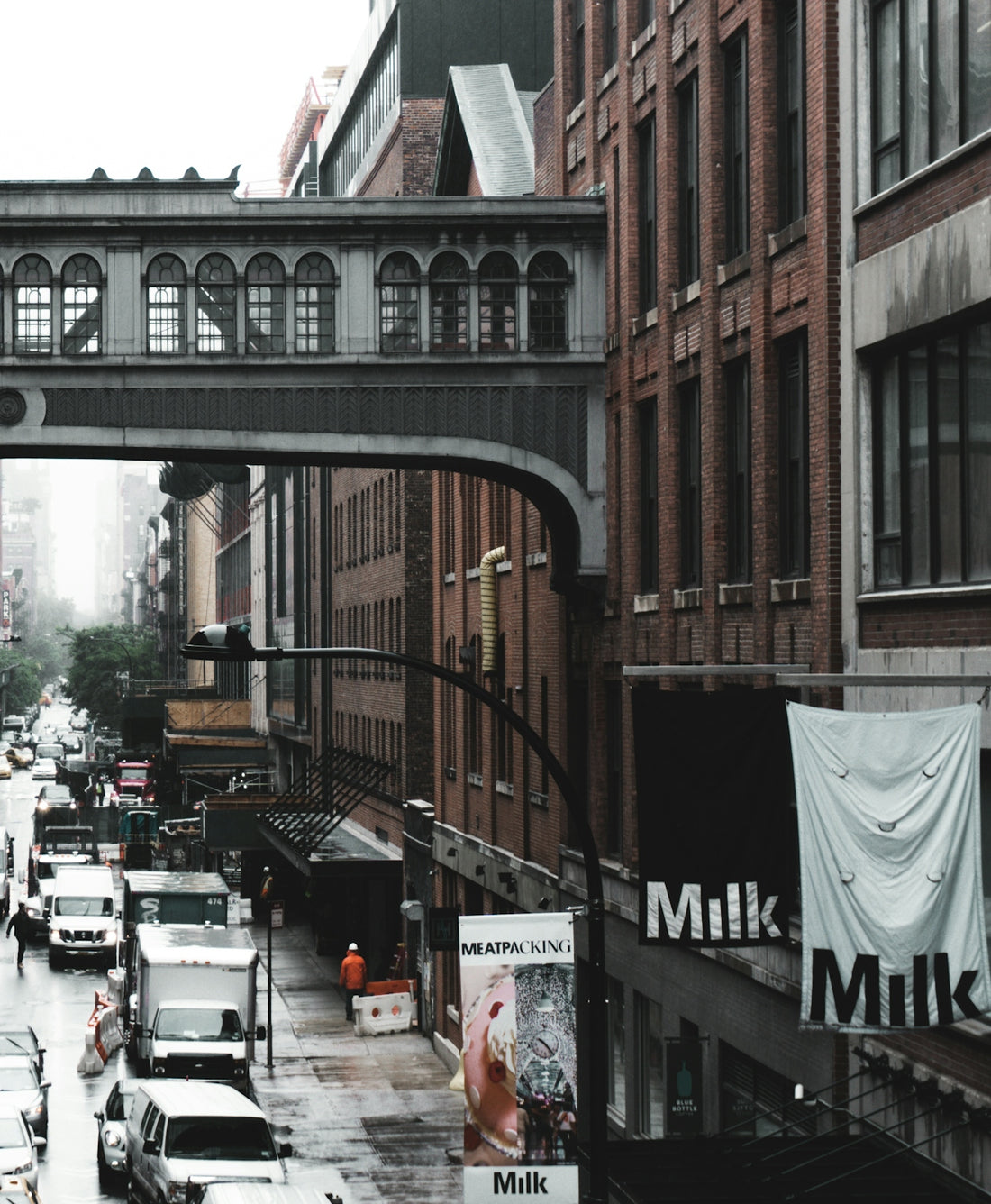 a city street filled with lots of traffic under a bridge