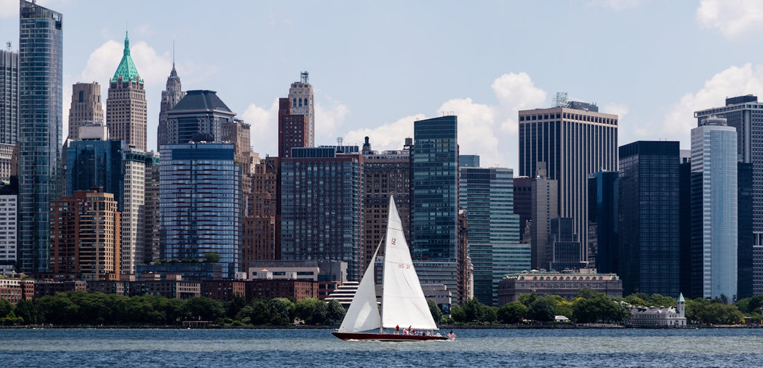 a sailboat in a body of water in front of a large city