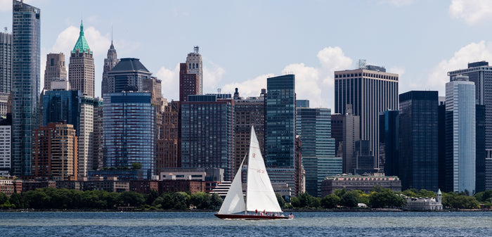 a sailboat in a body of water in front of a large city