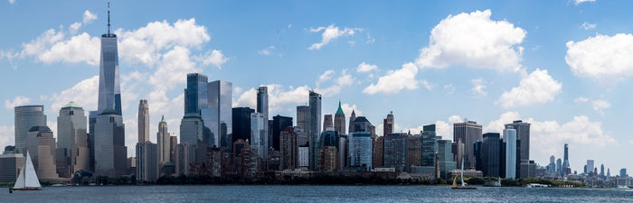 a city skyline with a sailboat in the foreground