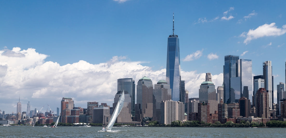 a sailboat sailing in front of a large city