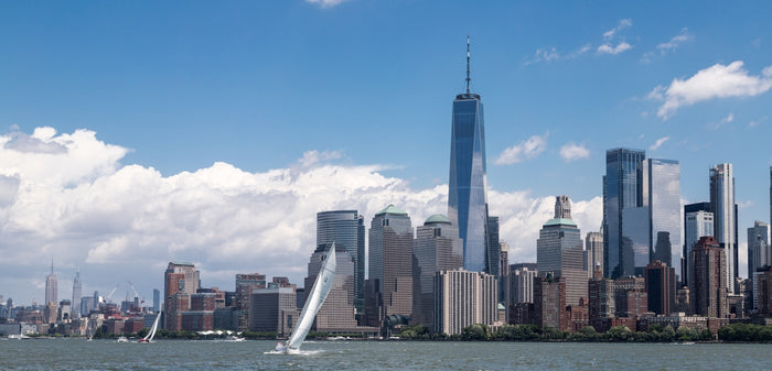a sailboat sailing in front of a large city