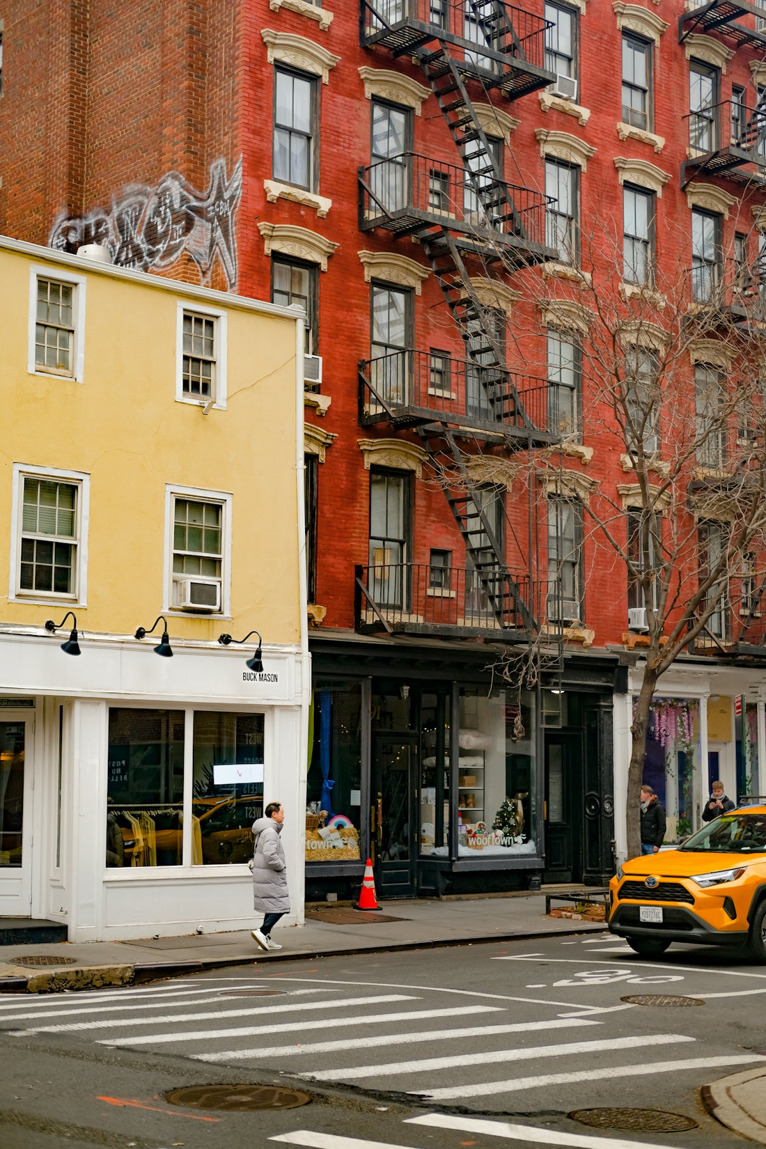 a city street with a yellow taxi cab and tall buildings