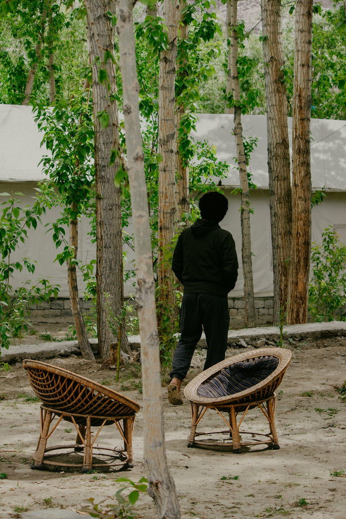 a man standing next to a bench in the woods