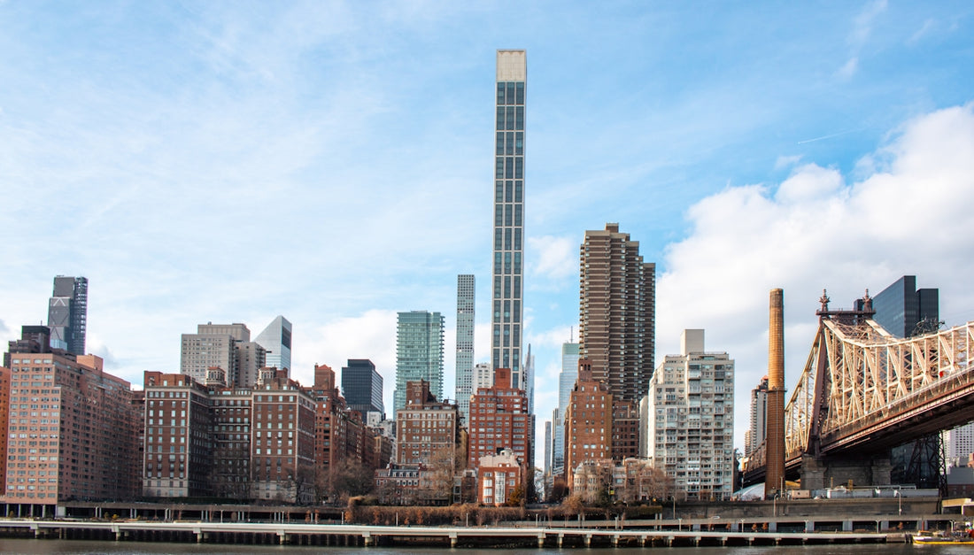 A tall skyscraper dominates the manhattan skyline.