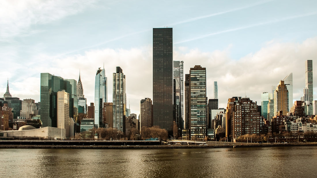 City skyline with several modern skyscrapers by water.