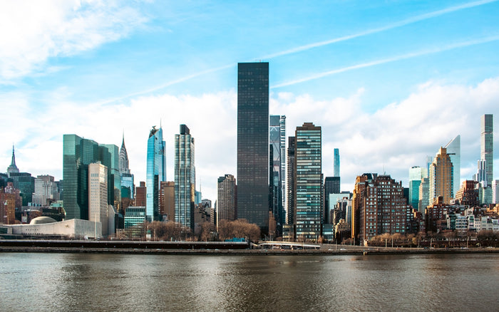 A skyline of buildings reflecting on water.