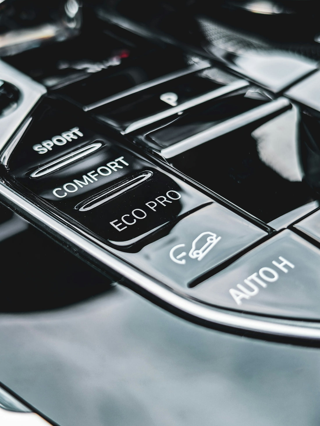 Car interior with driving mode selection buttons.