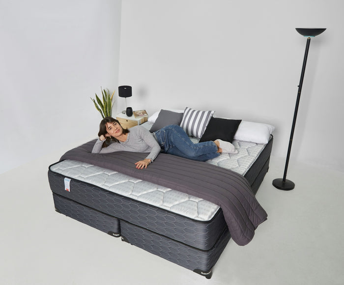 Woman relaxing on a large bed with pillows