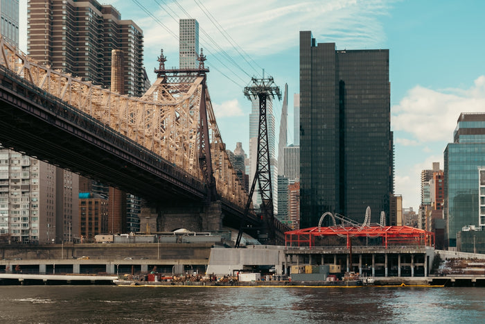 Queensboro bridge spans river with city skyline background
