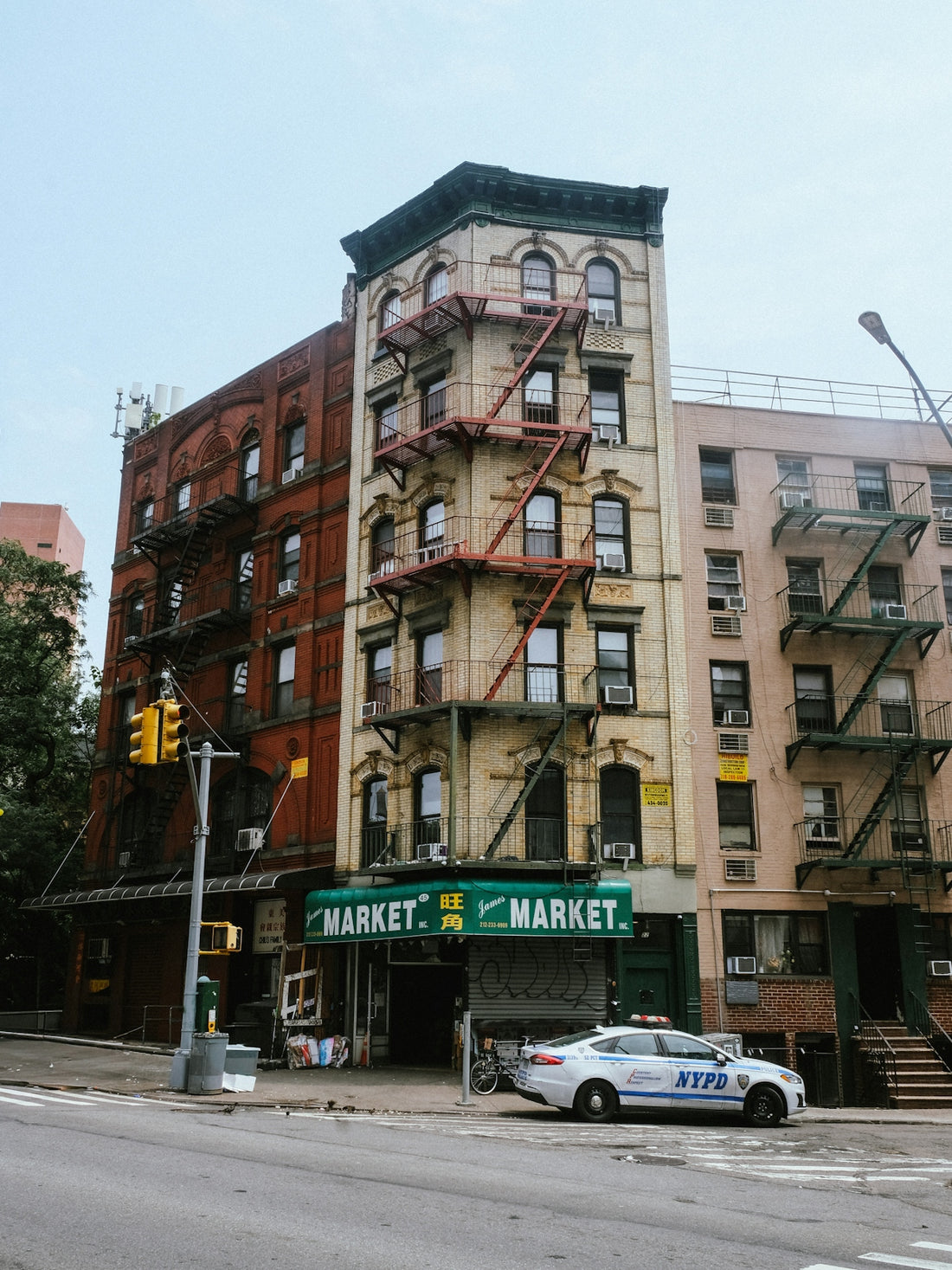 Apartment buildings with a market and police car.