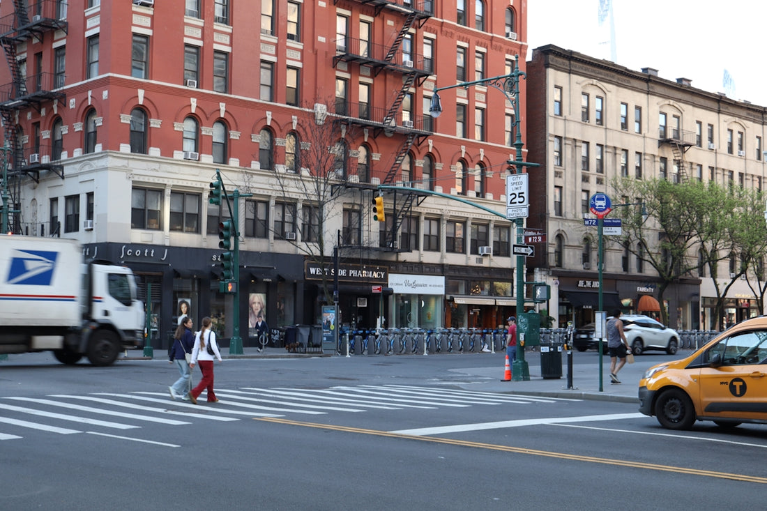 City street with buildings, traffic, and pedestrians crossing pedestrians.