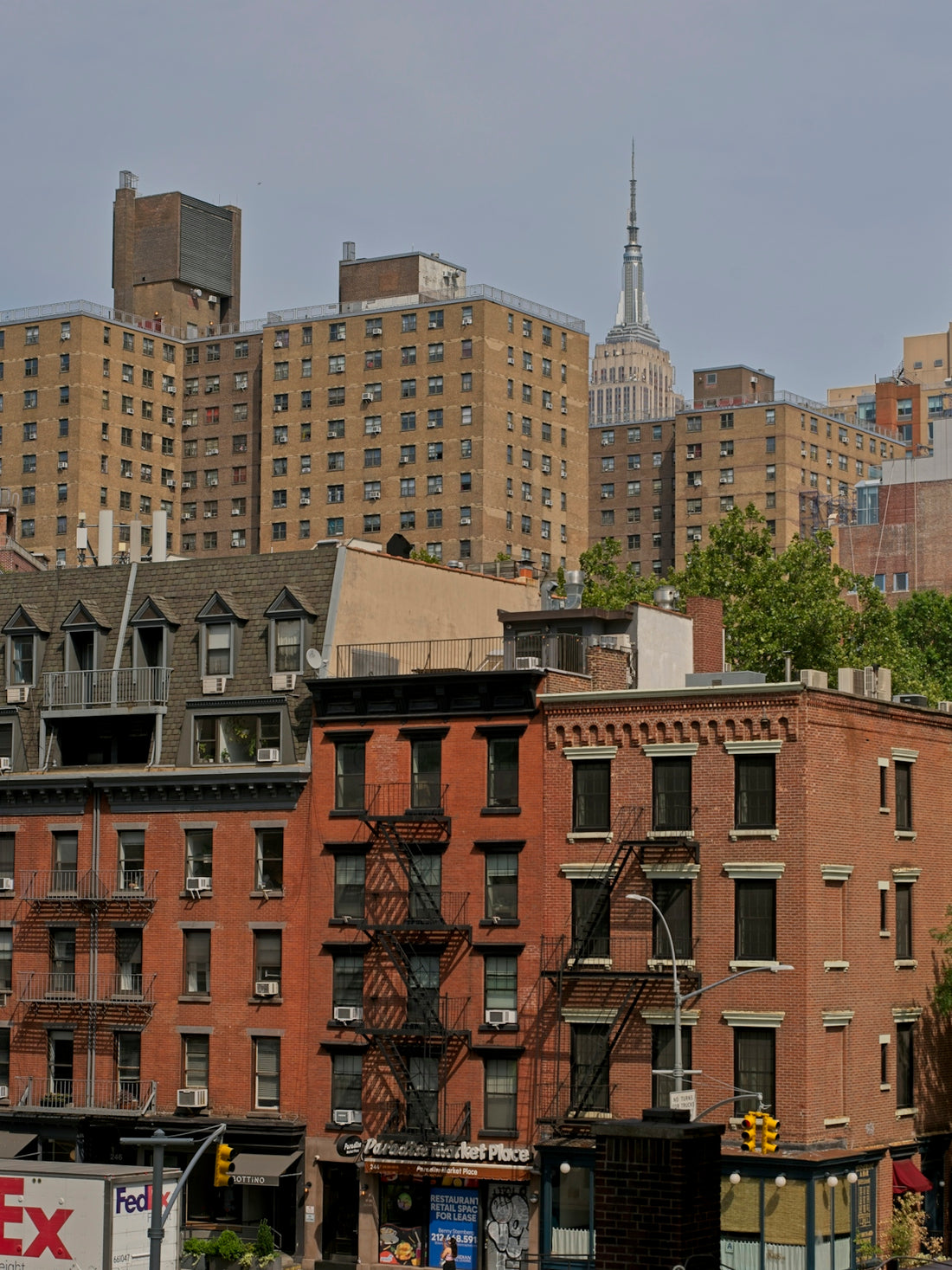Urban cityscape with brick buildings and empire state building spire.