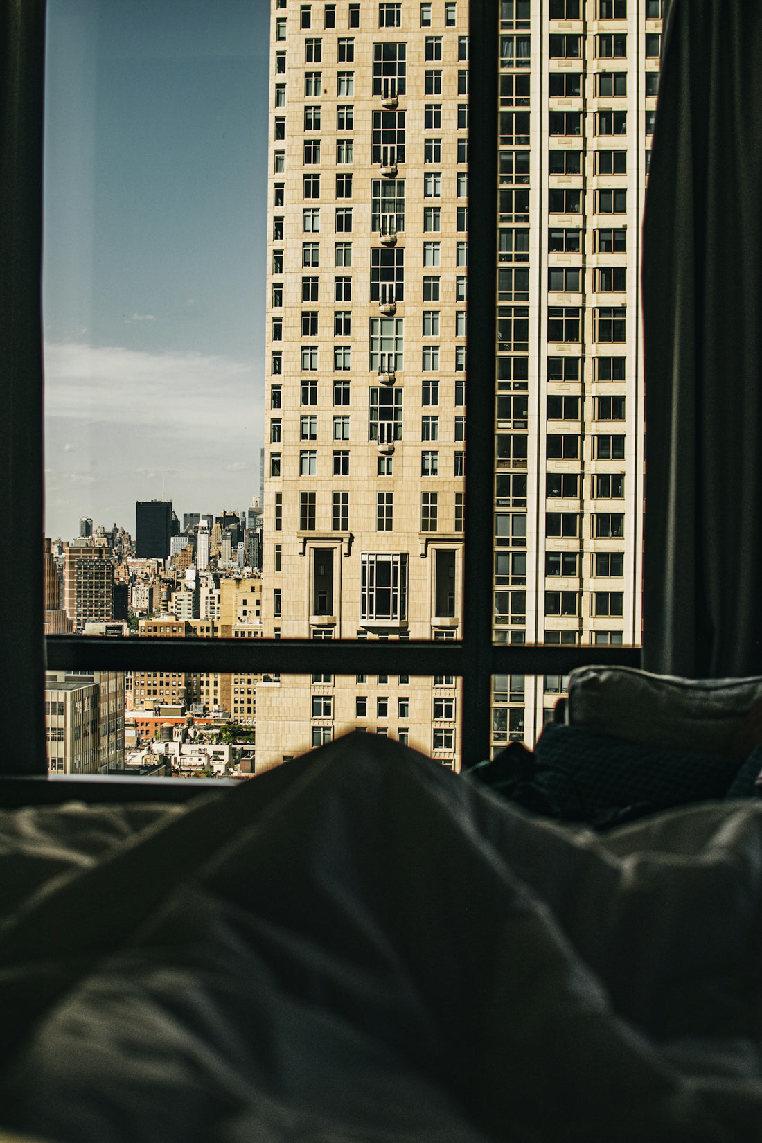 City building and skyline viewed from a bedroom window.
